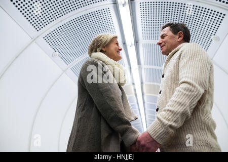 Älteres Paar im Flur der u-Bahn Hand in Hand Stockfoto