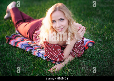 schöne junge Frau liegend auf dem Rasen im park Stockfoto