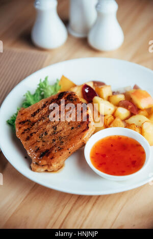 Steak mit knusprigen goldenen Pommes Frites und würziger Tomatensauce Stockfoto