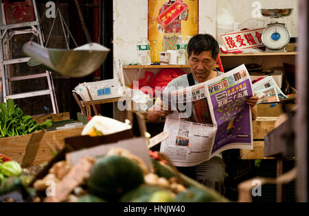 Unternehmer, die Lektüre der Zeitung im Stadtteil ChinaTown in New York City Stockfoto