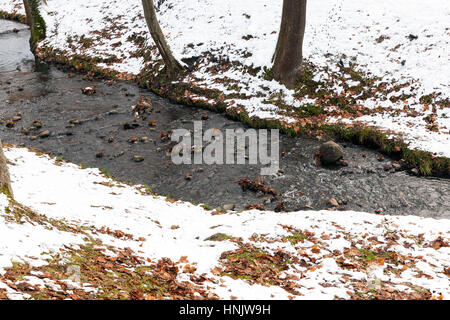 Flüsschen in der Wintersaison. Die Banken sind mit gefallenen Schnee bedeckt. Foto Nahaufnahme, kleine Schärfentiefe. Belarus Stockfoto