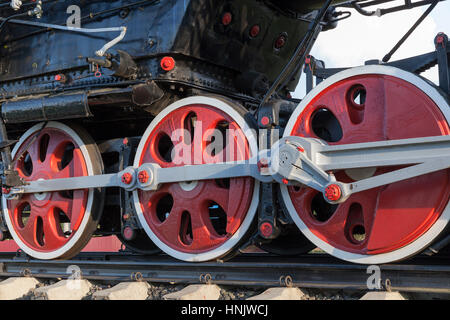 fotografiert in der Nähe eine alte Dampf Lok Räder mit schwarz in rot lackiert. Das Foto wurde aufgenommen in rot. Stockfoto