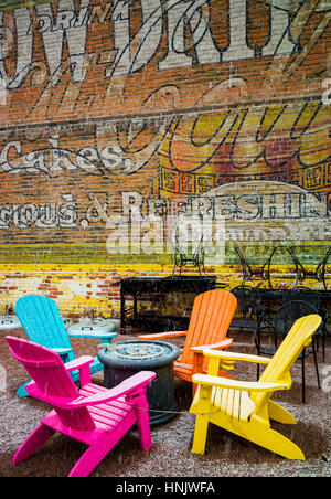 Bunte Gartenstühle & bunte Wandwandbild im Schnee auf der Terrasse des Restaurant Bootshaus Cantina; Salida; Colorado: USA Stockfoto