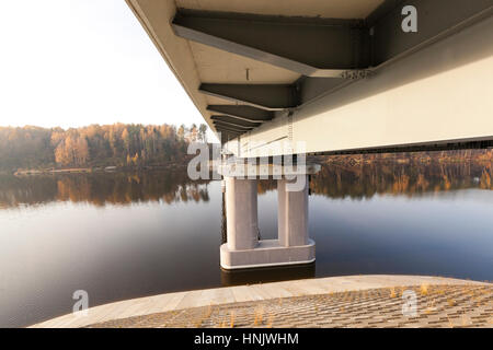 neue Brücke über den Fluss, hergestellt aus Beton und Metall. Das Foto wurde Nahaufnahme am unteren Rand der Struktur, sichtbaren Spalten und den Fluss. Stockfoto