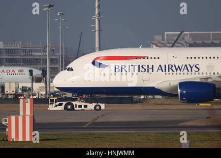 Eine British Airways-Airbus A380 wird gezogen von einem Douglas TBL-600 Schlepper am Flughafen London Heathrow Stockfoto