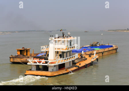 Drei Schlepper schieben Lastkähne auf dem Irrawaddy Fluss in Myanmar (Burma). Stockfoto