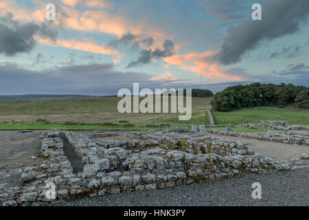 Der Hadrianswall, römisches Kastell Housesteads: der Blick über die Reste einer Baracke Gebäude (Baracke 13) aussehende Nord-Ost über die Knag Burn Stockfoto