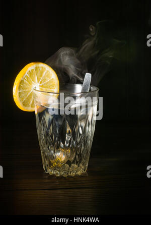 Transparente Glasschale mit Schwellen das kochende Wasser hinein. Der Dampf von oben. Schwarzer Hintergrund. Platz für Text. Stockfoto