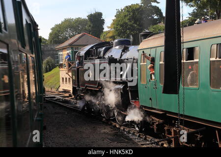 Standard-Klasse 4 2-6-4 Tank loco 80103 dampft Swanage Hauptbahnhofs mit Fahrer, Passagiere und Stellwerkswärter Stockfoto