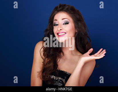 Aufgeregt schöne Make-up Frau verzog das Gesicht und zeigt oops melden Sie ihre Hand auf blauem Hintergrund. Closeup portrait Stockfoto