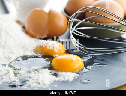 Zusammensetzung des rohen Eiern Fokus auf das Eigelb mit Mehl und Vollei im Hintergrund, selektiven Fokus auf Kopie Werbefläche, Stockfoto