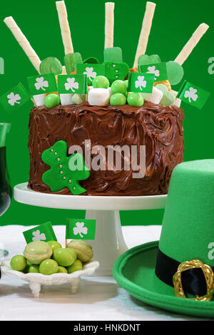 Glücklich St. Patricks Day, März 17, grün-weiße Party Tisch mit Showstopper Schokolade Kuchen mit Süßigkeiten, Kekse und Shamrock Flaggen geschmückt. Stockfoto