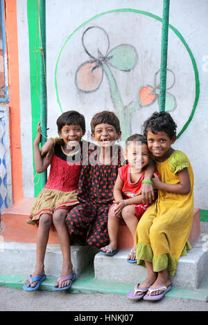 Kinder in Thangra Slum in Kalkutta sitzen vor einer Wand bemalt mit Blumen, Indien, Asien Stockfoto