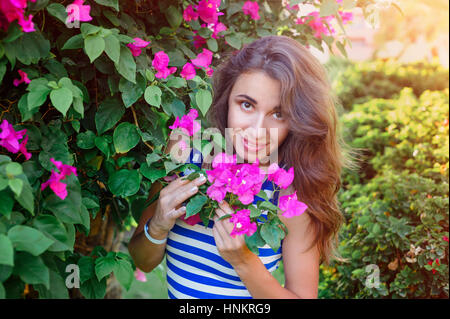 schöne junge Frau in der Nähe der blühende bougainvillea Stockfoto