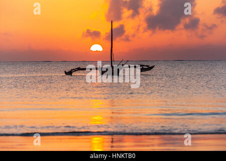 Sonnenaufgang über dem indischen Ozean. Holzboot auf dem Strand von Mombasa mit wunderschönen Sonnenaufgang auf dem background.silhouette Fischerboot in den Strahlen der eine ein Stockfoto
