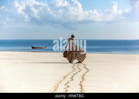 Fischer in Kenia, Wasser, Natur, Menschen, Angeln, Meer, Wolken, Afrika, Mann Fischer in den frühen Morgenstunden zu Fuß entlang des Sands zum Boot, Stockfoto