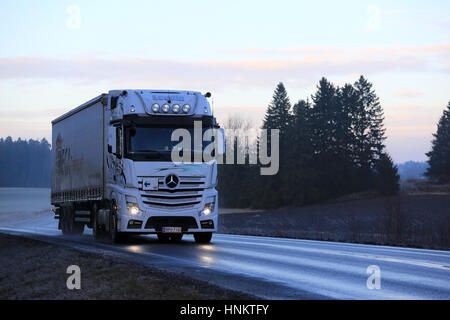 SALO, Finnland - 1. Januar 2017: Weiße Mercedes-Benz Actros Cargo Sattelschlepper von V. Levola Oy Ware Weg an einem nebligen Winterabend in liefert So Stockfoto