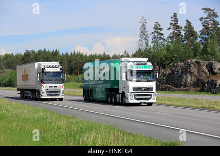 PAIMIO, Finnland - 3. Juni 2016: Volvo FH OKline Semi Trailer Flachglas-Transport-Anhänger überholt ein weiterer Volvo FH-Sattelschlepper auf Autobahn im Sommer. Stockfoto