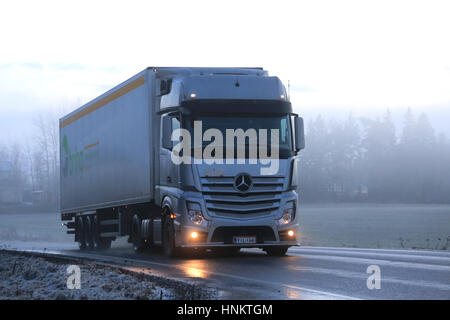 SALO, Finnland - 1. Januar 2017: Silber Mercedes-Benz Actros 1845 Semi transportiert Bring Anhänger Weg an einem nebligen Winterabend. Stockfoto