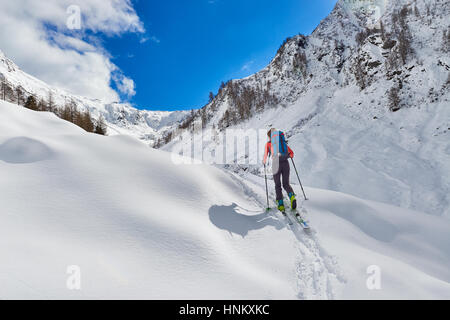 Mädchen macht Ski Alpinismus bergauf allein in den Alpen Stockfoto