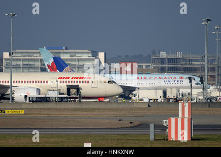 Frachtflugzeuge. Verschiedene Flugzeuge auf ihren Ständen am Flughafen London Heathrow werden für ihre Flüge beladen Stockfoto