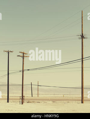 Telefonmasten und Stromleitungen in der Nähe von Trona (Kalifornien). Stockfoto