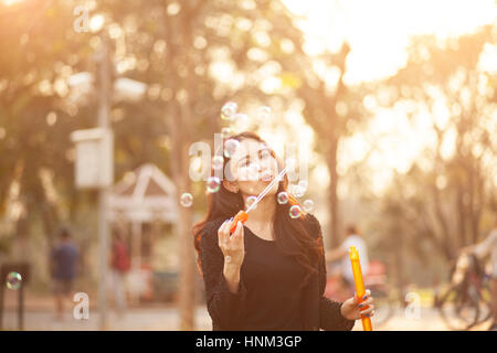 Hübsches Thai Mädchen bläst ein Blasen im Park Stockfoto