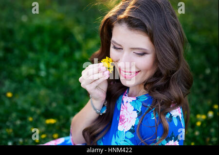 schöne junge Frau, die eine Blume Stockfoto