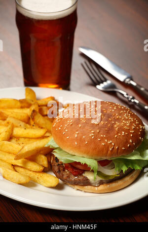 Foto von einen Burger mit Pommes Frites und ein kühles Bier in einem Pub serviert. Stockfoto