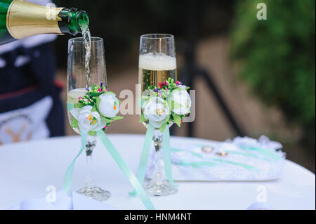 zwei Hochzeit Glas gießen Champagner mit Blumen geschmückt Stockfoto