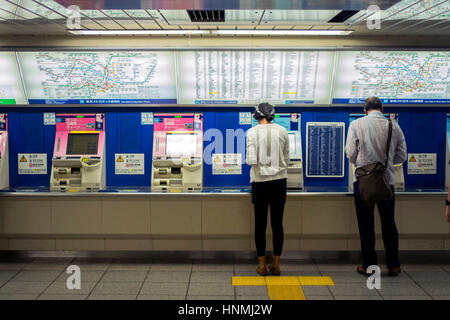 Passagiere der Kauf von Tickets an Automaten an der u-Bahnstation in Tokyo, Japan. Stockfoto