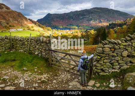 Eine junge Frau nimmt in der Ansicht über Glenridding und Ullswater. Nationalpark Lake District, Cumbria, England. Stockfoto