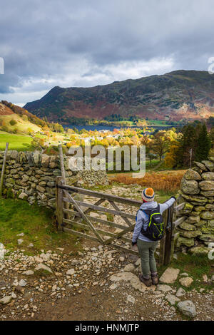 Eine junge Frau nimmt in der Ansicht über Glenridding und Ullswater. Nationalpark Lake District, Cumbria, England. Stockfoto