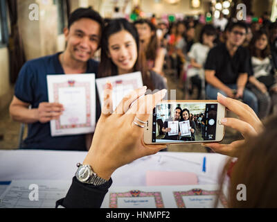 Bangkok, Thailand. 14. Februar 2017. Ein paar hat ihre Hochzeitsfoto mit ihrem iPhone im Bezirk Bang Rak in Bangkok. Bang ist Rak ein beliebtes Viertel für Hochzeiten in Bangkok, weil er übersetzt als "Dorf der Liebe." (Bang übersetzt als Dorf, Rak übersetzt Liebe.) Hunderte von Paaren heiraten im Bezirk am Valentinstag, das trotz seiner katholischen Herkunft, weit verbreitet in Thailand gefeiert wird. Bildnachweis: Jack Kurtz/ZUMA Draht/Alamy Live-Nachrichten Stockfoto