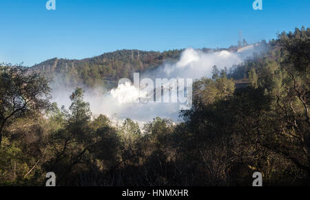 Oroville, Kalifornien, USA. 14. Februar 2017. Eine Spray Wolke hängt über, wie 100.000 Kubikfuß pro zweite Abfluss von Wasser gießt vorbei an den beschädigten Oroville Abflußkanal 14. Februar 2017 in Oroville, Kalifornien. Reparatur der Hochwasserentlastung und Deiche entlang der Flüsse Feder und Sacramento und die landesweit höchste Staumauer haben begonnen und die obligatorischen Evakuierung-Reihenfolge, die 200.000 Menschen betroffen wurde aufgehoben.        (Florenz Low/Kalifornien DWR über Planetpix) Bildnachweis: Planetpix/Alamy Live-Nachrichten Stockfoto