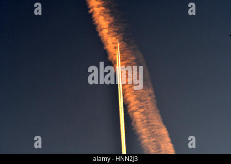 Berlin, Deutschland. 15. Februar 2017. Ein Flugzeug überquert Kondensstreifen am frühen Morgen in Berlin, Deutschland, 15. Februar 2017. Foto: Paul Zinken/Dpa/Alamy Live News Stockfoto