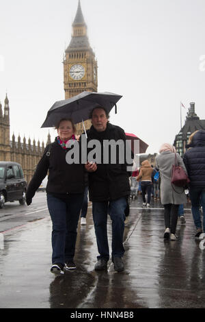 London UK, 15. Februar 2017. Fußgänger schützen vor dem Regenschauer auf Westminster Bridge an einem stürmischen verunsichert Tag Credit: Amer Ghazzal/Alamy Live-Nachrichten Stockfoto