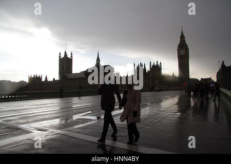 London UK, 15. Februar 2017. Fußgänger schützen vor dem Regenschauer auf Westminster Bridge an einem stürmischen verunsichert Tag Credit: Amer Ghazzal/Alamy Live-Nachrichten Stockfoto