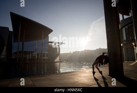 Berlin, Deutschland. 15. Februar 2017. Eine Tänzerin posiert für ein Foto, wie die Sonne über der Regierung Bezirk von Berlin, Deutschland, 15. Februar 2017 aufgeht. Foto: Kay Nietfeld/Dpa/Alamy Live News Stockfoto