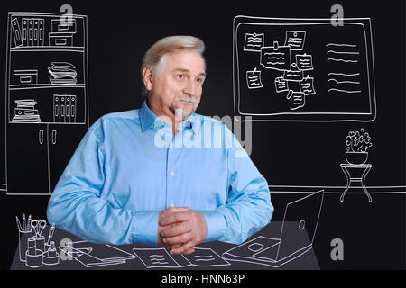 Positiv erfreut Mann am Tisch sitzen Stockfoto