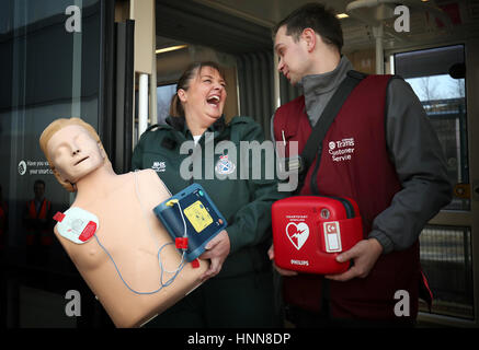 Sam Grieve (links), von den schottischen Rettungsdienst und Straßenbahn Teamleiter Piotr Rogula bei Gogar-Straßenbahndepot in Edinburgh, mit einem neuen Defibrillatoren, die auf der Hauptstadt installiert wurden Straßenbahn Netz als Teil einer Kampagne zur Herzinfarktopfer retten. Stockfoto