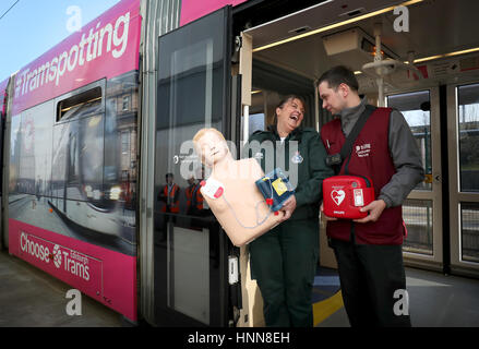 Sam Grieve (links), von den schottischen Rettungsdienst und Straßenbahn Teamleiter Piotr Rogula bei Gogar-Straßenbahndepot in Edinburgh, mit einem neuen Defibrillatoren, die auf der Hauptstadt installiert wurden Straßenbahn Netz als Teil einer Kampagne zur Herzinfarktopfer retten. Stockfoto