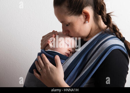 Mutter mit ihrem Baby Sohn schlafen im Tragetuch. Studio gedreht. Stockfoto