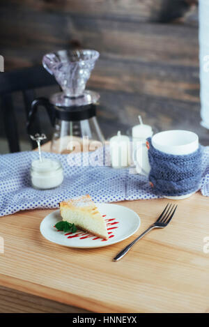 Dreieck-Käse-Kuchen im Café. Auf einem Holztisch Stockfoto