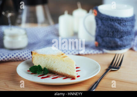 Dreieck-Käse-Kuchen im Café. Auf einem Holztisch Stockfoto