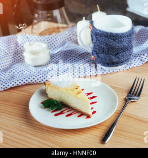 Dreieck-Käse-Kuchen im Café. Auf einem Holztisch Stockfoto