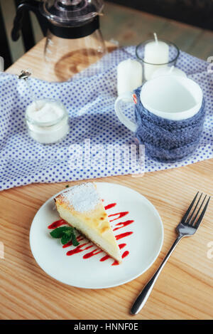 Dreieck-Käse-Kuchen im Café. Auf einem Holztisch Stockfoto