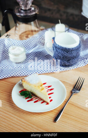 Dreieck-Käse-Kuchen im Café. Auf einem Holztisch Stockfoto