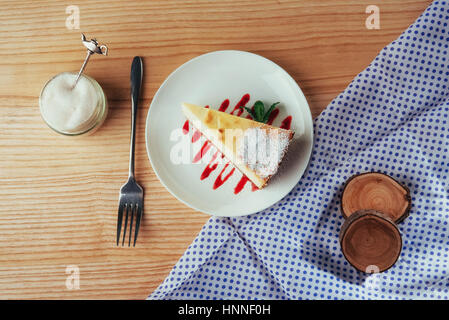 Dreieck-Käse-Kuchen im Café. Auf einem Holztisch Stockfoto