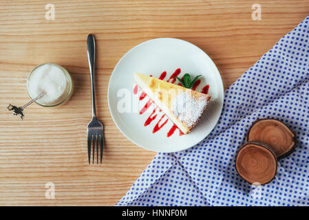 Dreieck-Käse-Kuchen im Café. Auf einem Holztisch Stockfoto